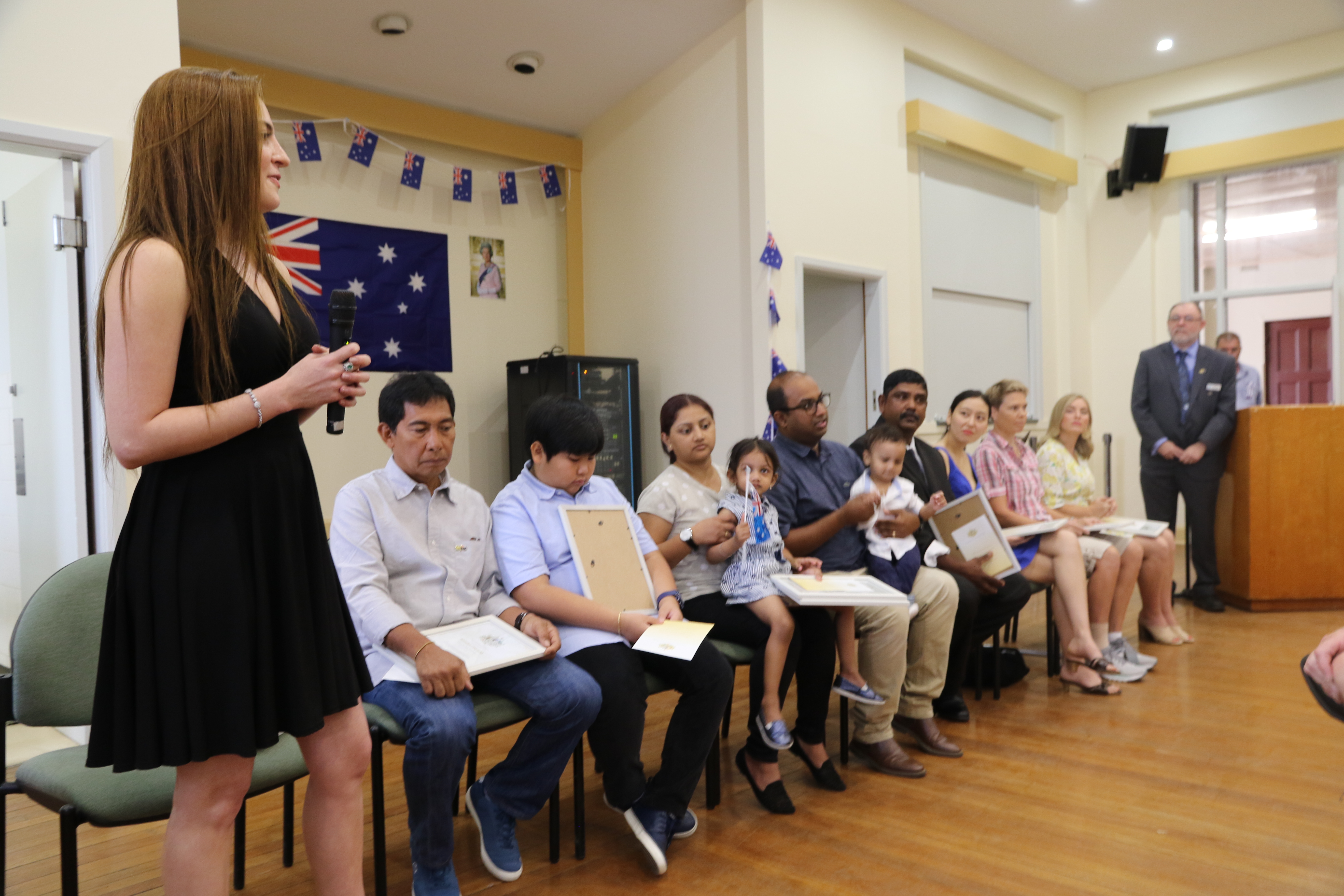 Doctor Nada Abu Alru speaking to the Moree community with the New Australia Citizens seated next to her. 