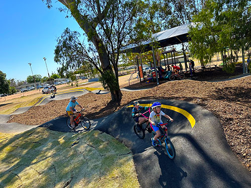 Kids enjoying riding their bikes at the opening of the Pally Pump Track